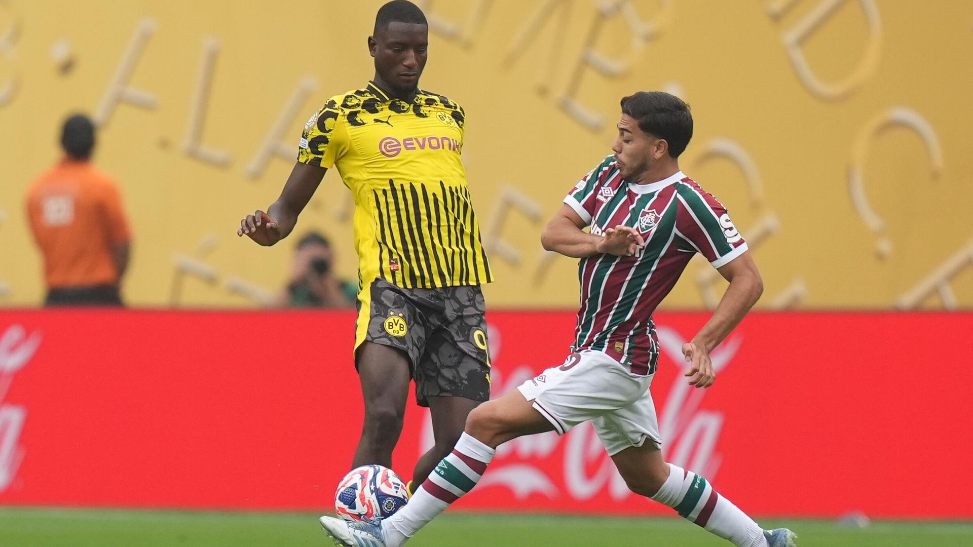Borussia Dortmund's Serhou Guirassy und Fluminense's Nonato kämpfen um den Ball. Borussia Dortmund's Serhou Guirassy und Fluminense's Nonato kämpfen um den Ball.