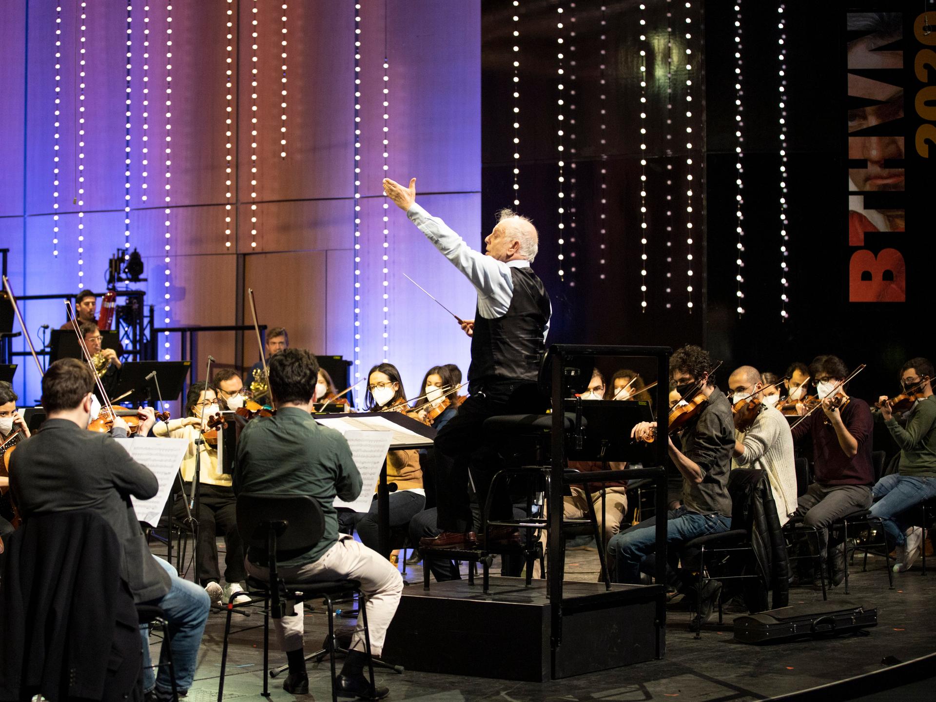 Mit vereinten Kräften: Dirigent Daniel Barenboim mit seinem Orchester zum Beethoven-Geburtstag 2020 in Bonn. Daniel Barenboim steht auf einem Pult in der Mitte und dirigiert, um ihn herum seine Symphoniker. 