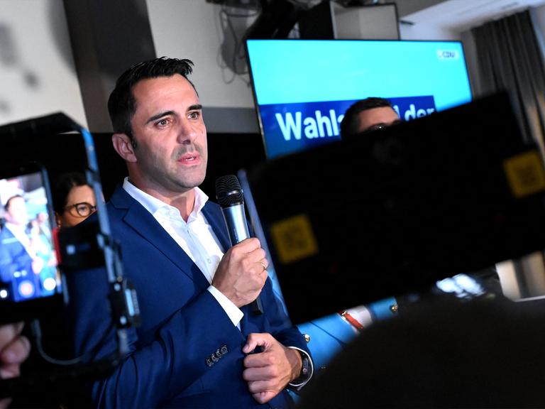 Daniel Peters steht bei der Wahlparty der CDU und spricht zu den Parteimitgliedernn.