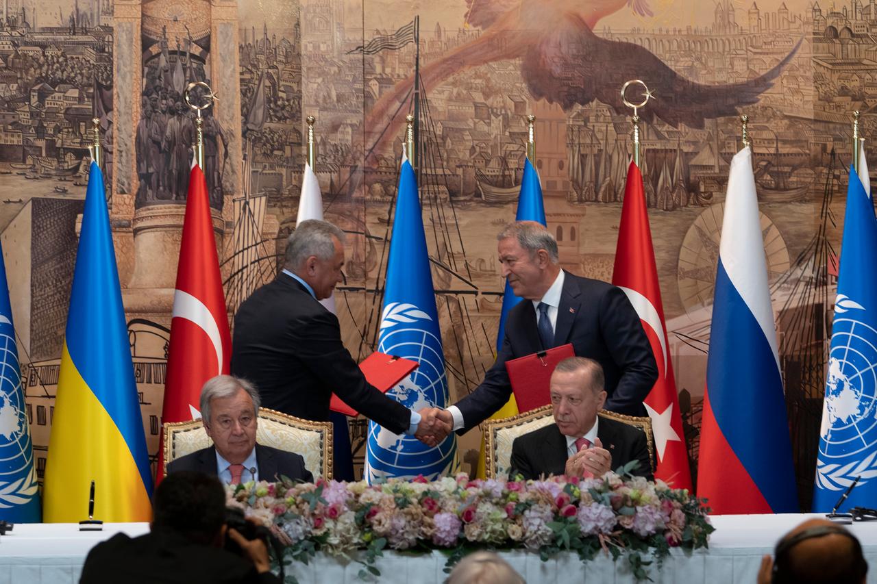 Zwei Abgesandte von Russland und der Ukraine schütteln sich die Hände, im Vordergrund sitzen der türkische Präsident Erdogan und UNO-Generalsekreätr Guterres.