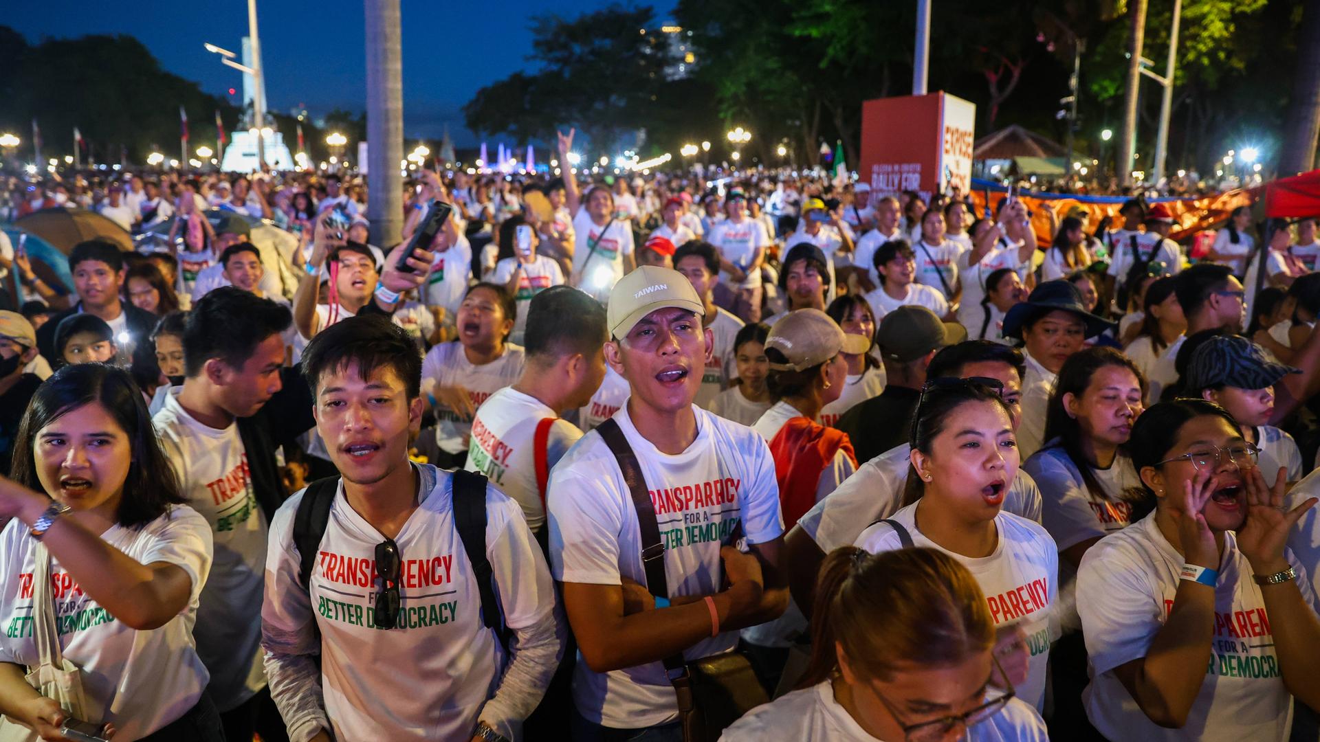 Viele Menschen haben sich in der philippinischen Hauptstadt Manila versammelt. Einige haben T-Shirts an, auf denen "Transparency" steht. Viele Menschen haben sich in der philippinischen Hauptstadt Manila versammelt. Einige haben T-Shirts an, auf denen "Transparency" steht.