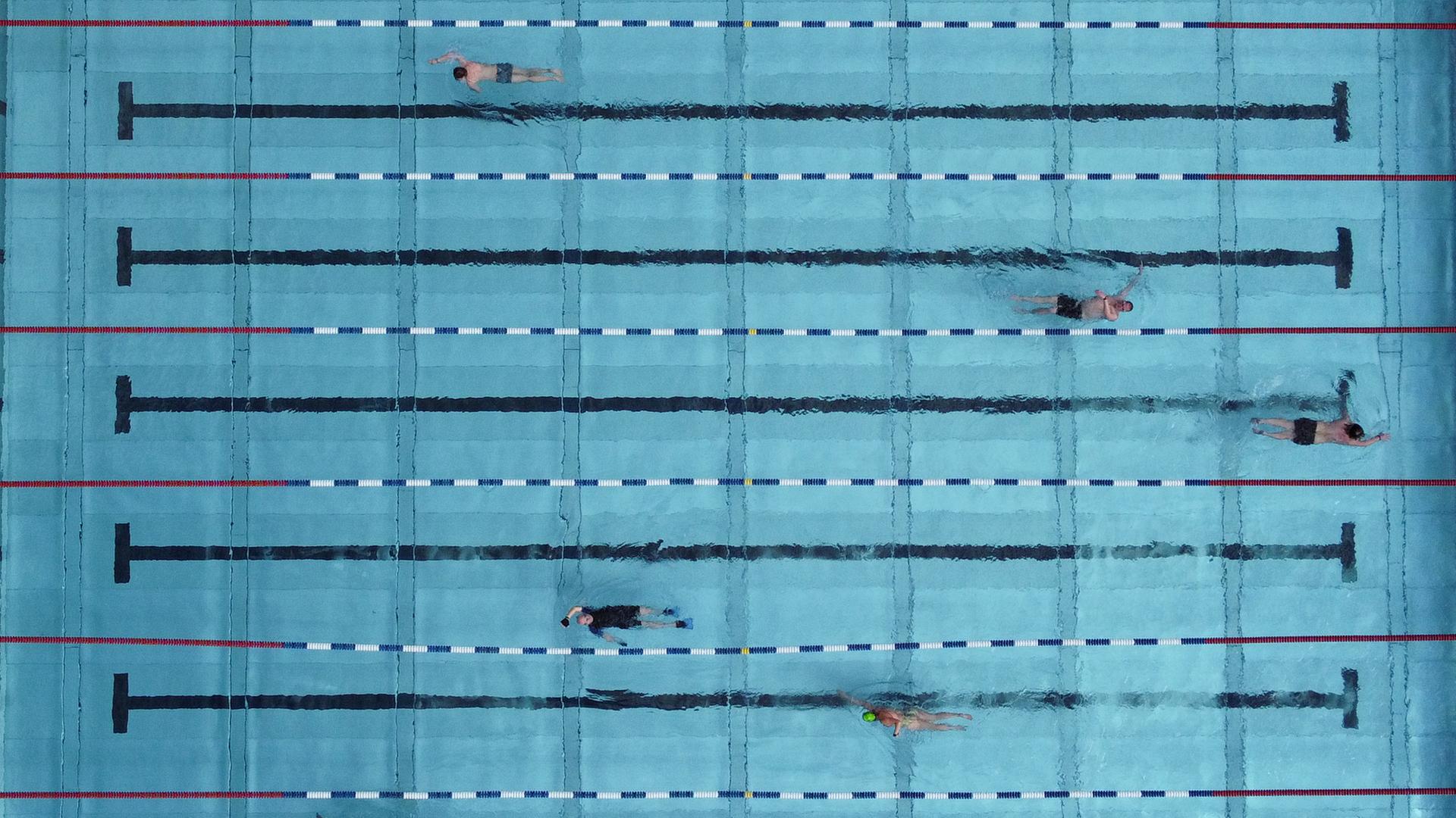 Schwimmer ziehen im Becken des Freibads Frankurt-Hausen ihre Bahnen (Luftaufnahme mit einer Drohne).