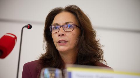 Die Vorsitzende des Deutschen Gewerkschaftsbundes, Yasmin Fahimi, sitzt während einer Pressekonferenz vor Mikrofonen.