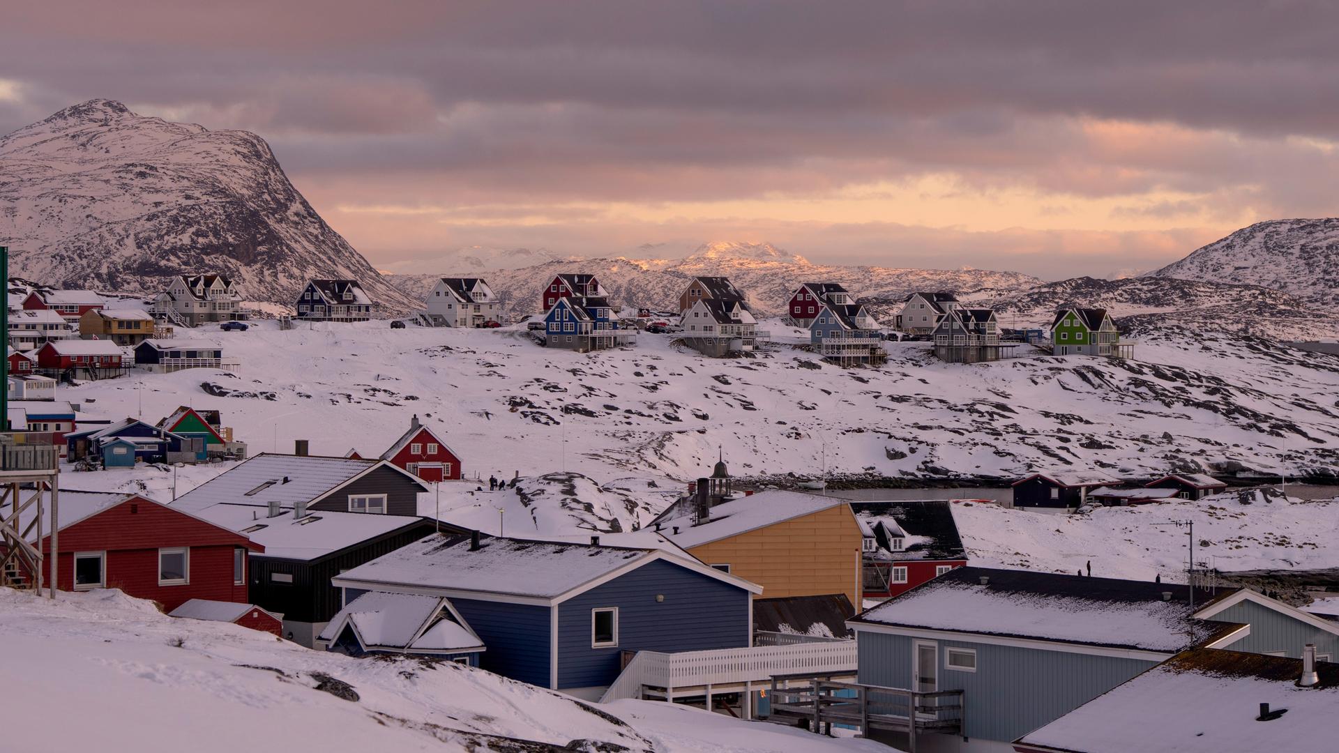 Verschneite Häuser in der grönländischen Hauptstadt Nuuk, hinter Wolken leuchtet die tiefstehende Sonne. Verschneite Häuser in der grönländischen Hauptstadt Nuuk, hinter Wolken leuchtet die tiefstehende Sonne.