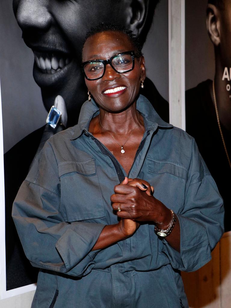 Auma Obama lacht in die Kamera. Sie trägt eine blaue Bluse und eine schwarz umrandete Brille.