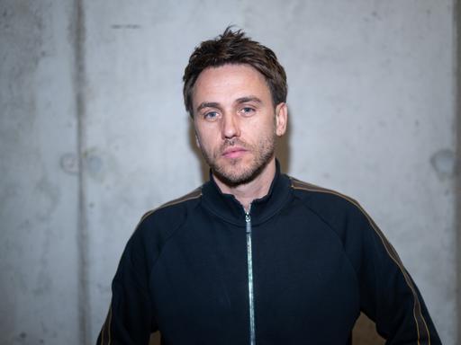 Clueso, Musiker, steht im Büro von Sony Music.