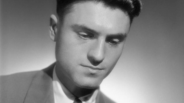 Schwarz-Weiß-Foto von Jacques Lusseyran, der einen Anzug trägt. Sein Blick ist leicht nach unten geneigt.