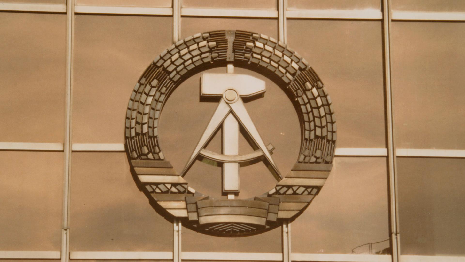 Das DDR-Staatswappen, bestehend aus Ährenkranz mit Hammer und Zirkel, prangt an der Westfassade des Palasts der Republik in Berlin