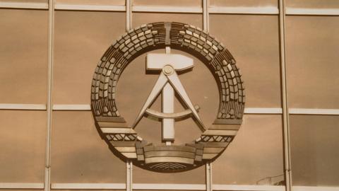 Das DDR-Staatswappen, bestehend aus Ährenkranz mit Hammer und Zirkel, prangt an der Westfassade des Palasts der Republik in Berlin