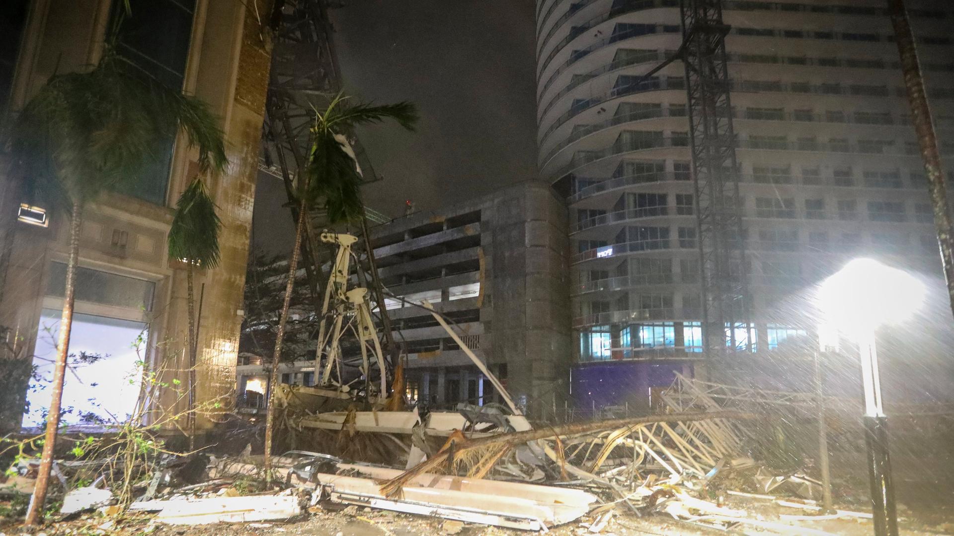 Trümmer bedecken den Boden in der Nähe eines Krans, der auf ein Gebäude entlang der 1st Avenue South in St. Petersburg, Florida, gefallen ist, als die starken Winde von Hurrikan Milton am Donnerstag, den 10. Oktober 2024, durch die Gegend fegten.