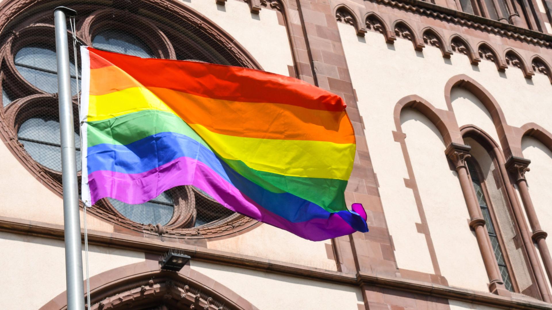 Eine Regenbogenfahne weht an der an der Herz-Jesu-Kirche in Freiburg . *** A rainbow flag flies at the Herz Jesu church in Freiburg, Germany