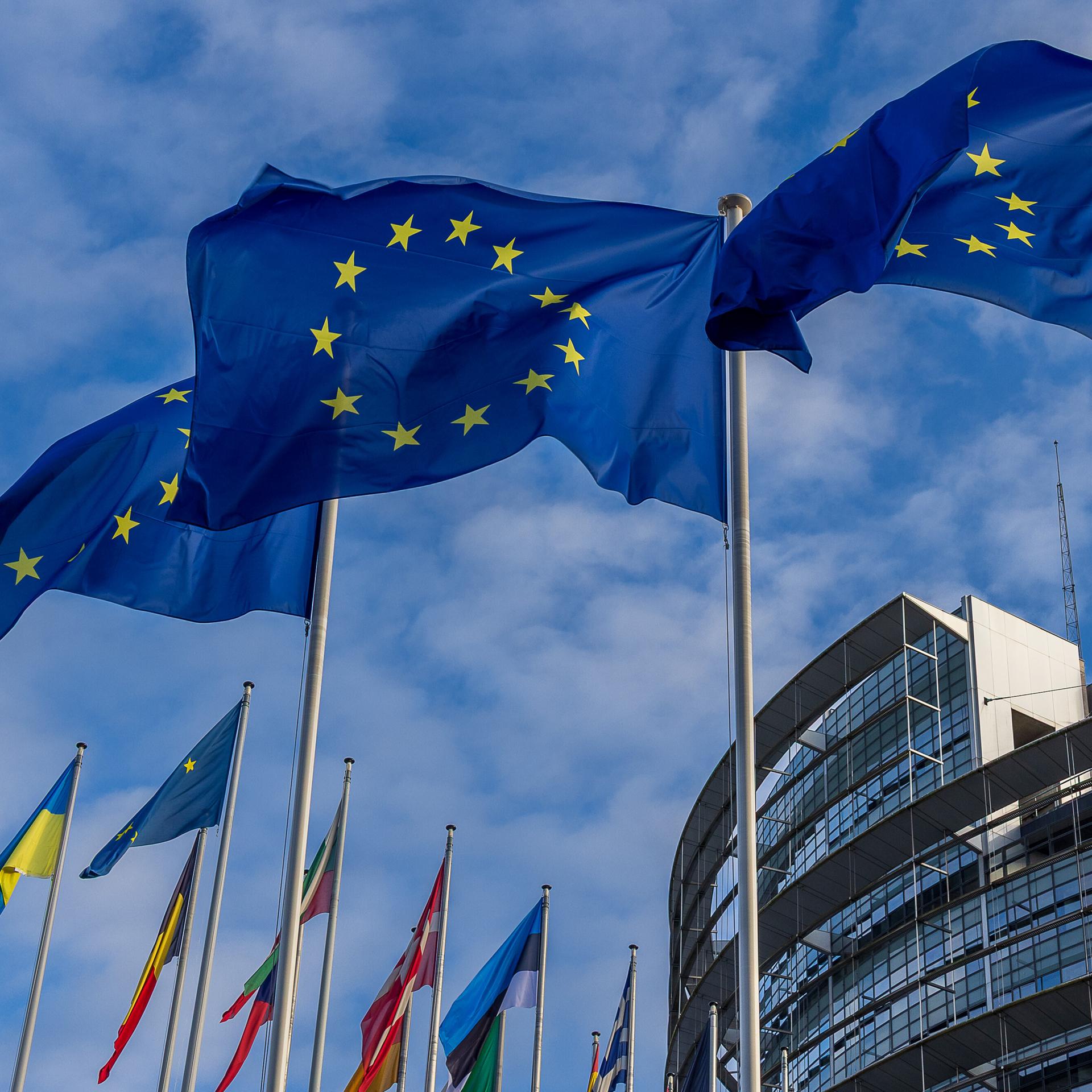 Drei Europaflaggen und mehrere Nationalflaggen wehen vor dem Gebäude des Europäischen Parlaments in Straßburg, Frankreich.