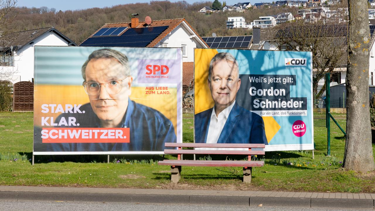 Wahlplakate der SPD mit Ministerpräsident Alexander Schweitzer (links) und CDU-Spitzenkandidat Gordon Schneider (rechts) stehen nebeneinander an der B42 in Erpel (Landkreis Neuwied).