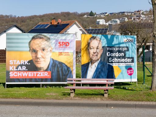 Wahlplakate der SPD mit Ministerpräsident Alexander Schweitzer (links) und CDU-Spitzenkandidat Gordon Schneider (rechts) stehen nebeneinander an der B42 in Erpel (Landkreis Neuwied).