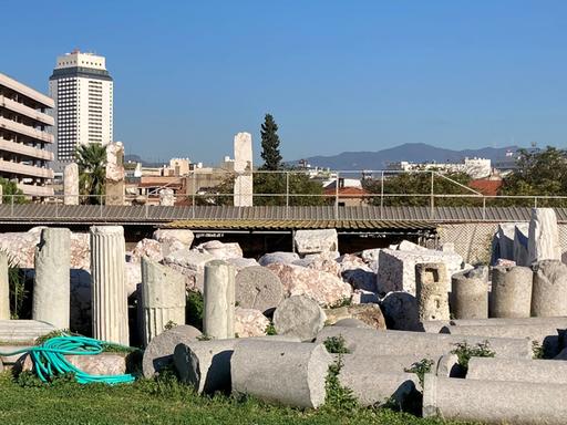 Blick auf alte Säulen vor einer Kulisser moderner Häuser in Izmir.