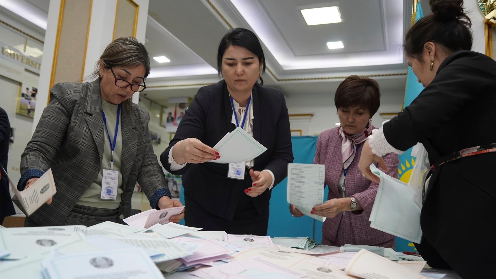 Kasachstan, Almaty: Mitglieder der Wahlkommission zählen die Stimmzettel in einem Wahllokal.