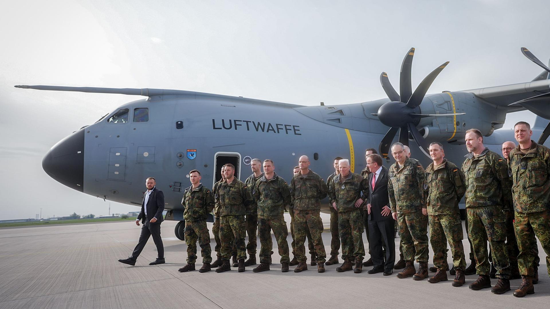 Die Soldaten und Verteidigungsminister Pistorius stehen in einer Reihe nebeneinander vor einer Bundeswehr-Maschine.