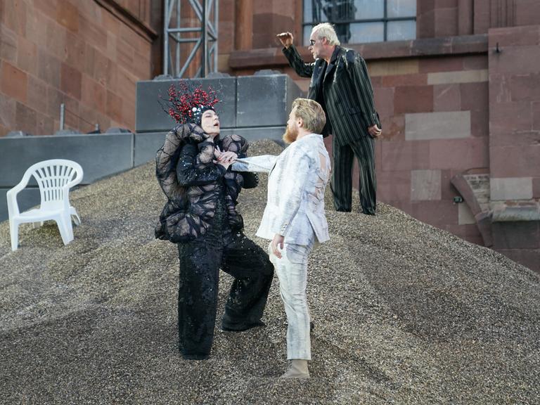 Drei Schauspieler stehen bei der Aufführung der Nibelungen-Festspiele in Worms auf einem Berg aus Kies. 