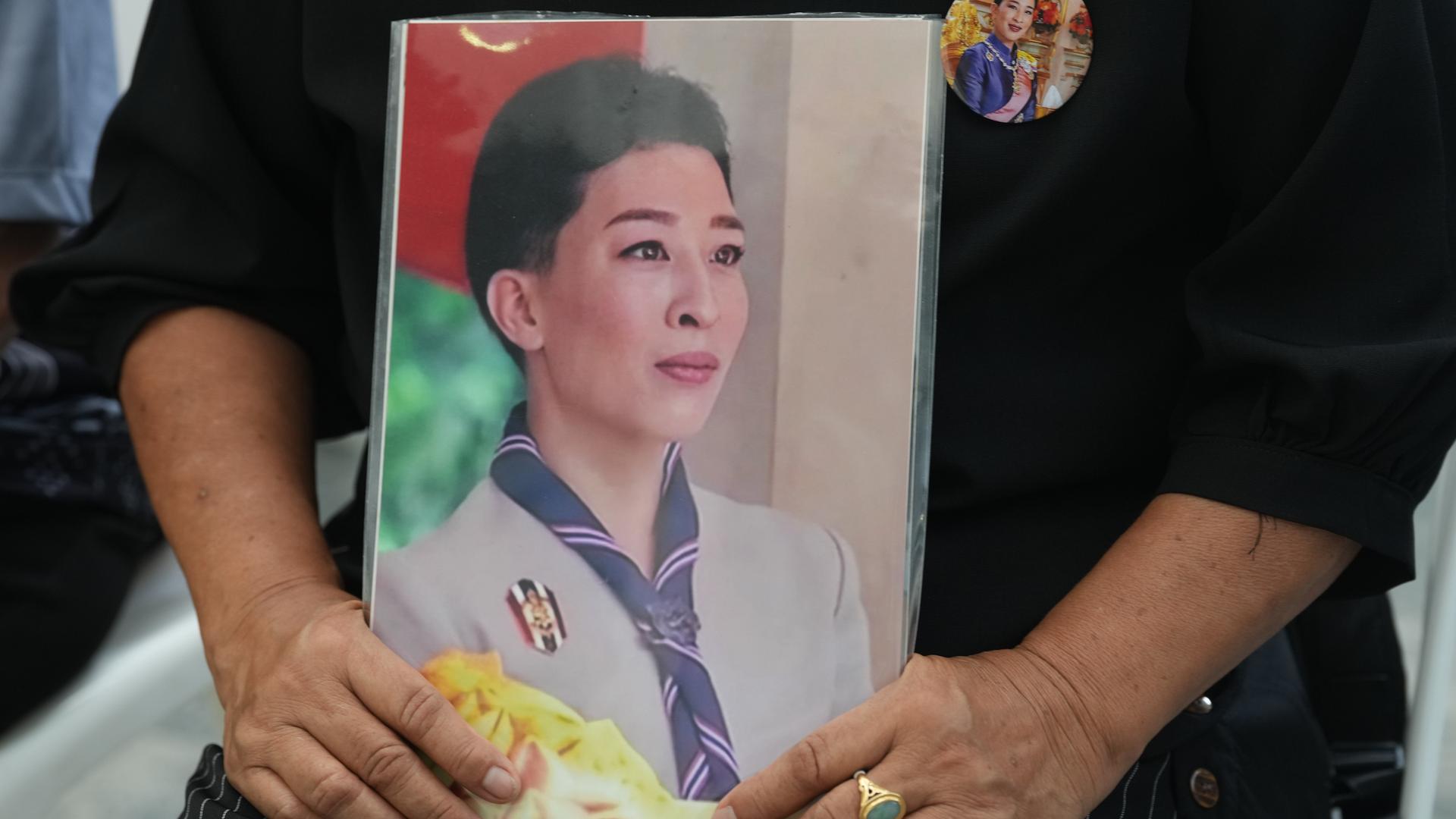 Eine Person hält ein Bild der verstorbenen thailändischen Prinzessin Bajrakitiyabha Mahidol in den Händen.