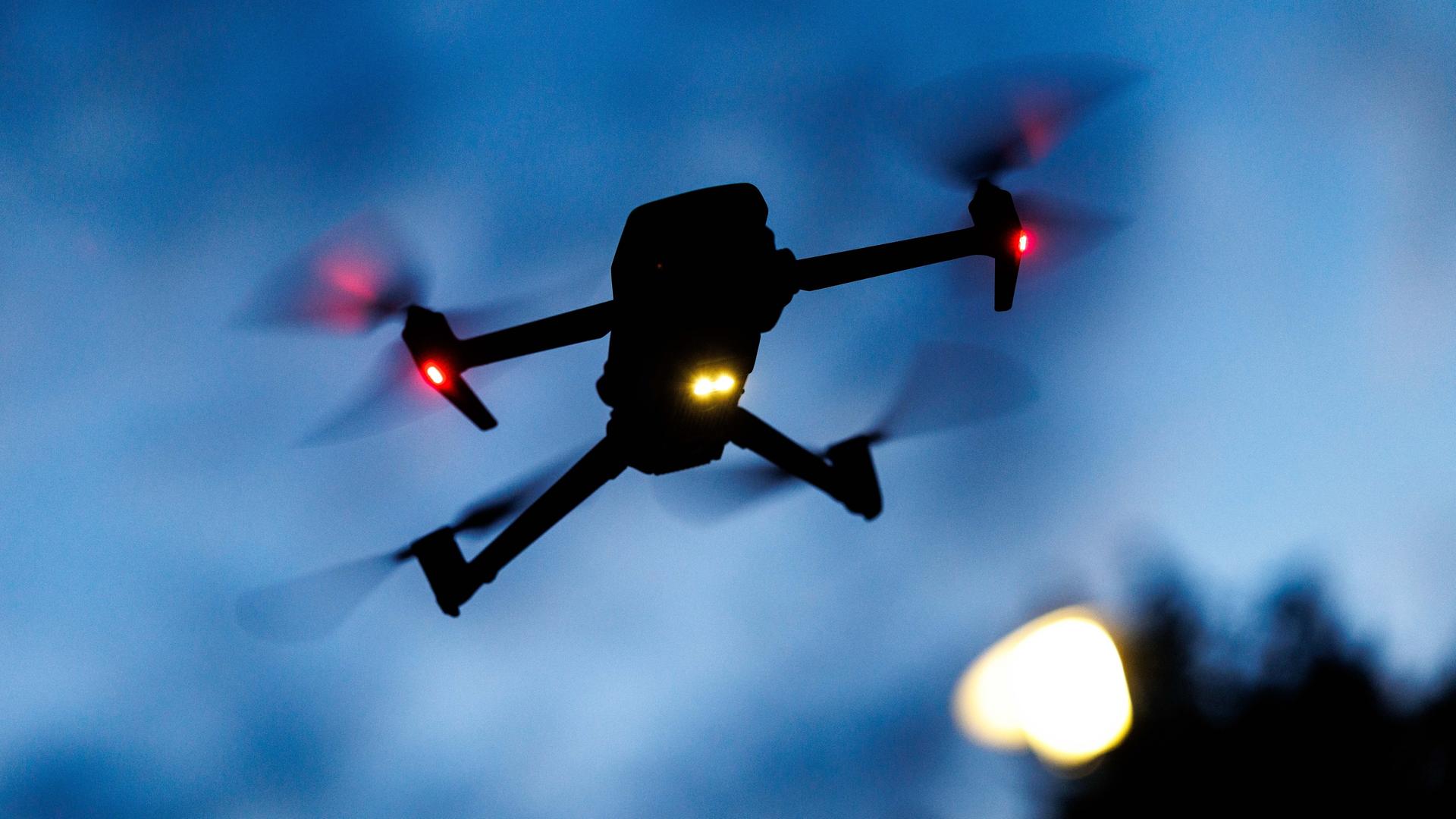 Eine Kameradrohne vom Typ DJI Mavic 3 Pro fliegt in der Dämmerung. Eine Kameradrohne vom Typ DJI Mavic 3 Pro fliegt in der Dämmerung.