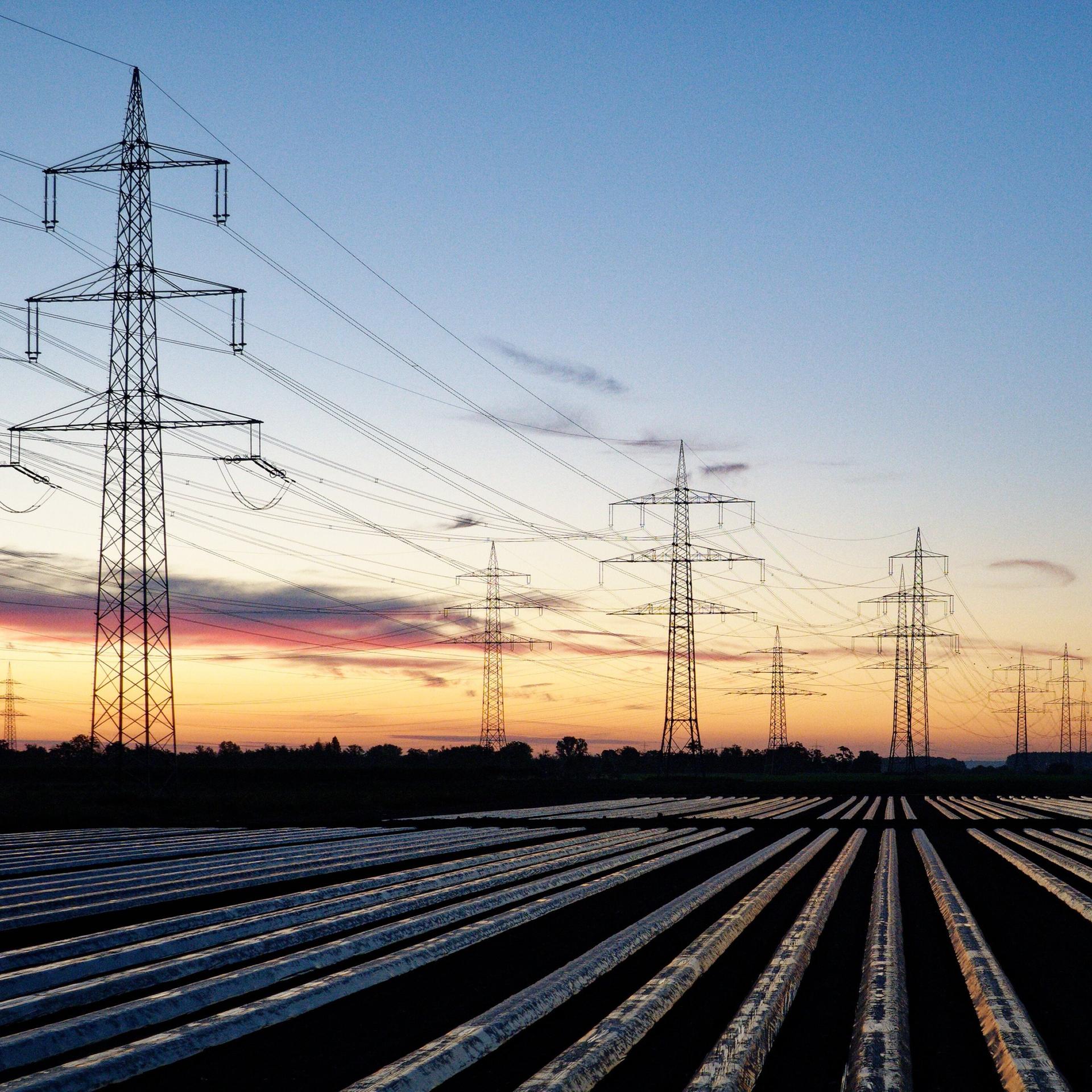 Windräder und Hochspannungsleitungen, aufgenommen am Morgen. 