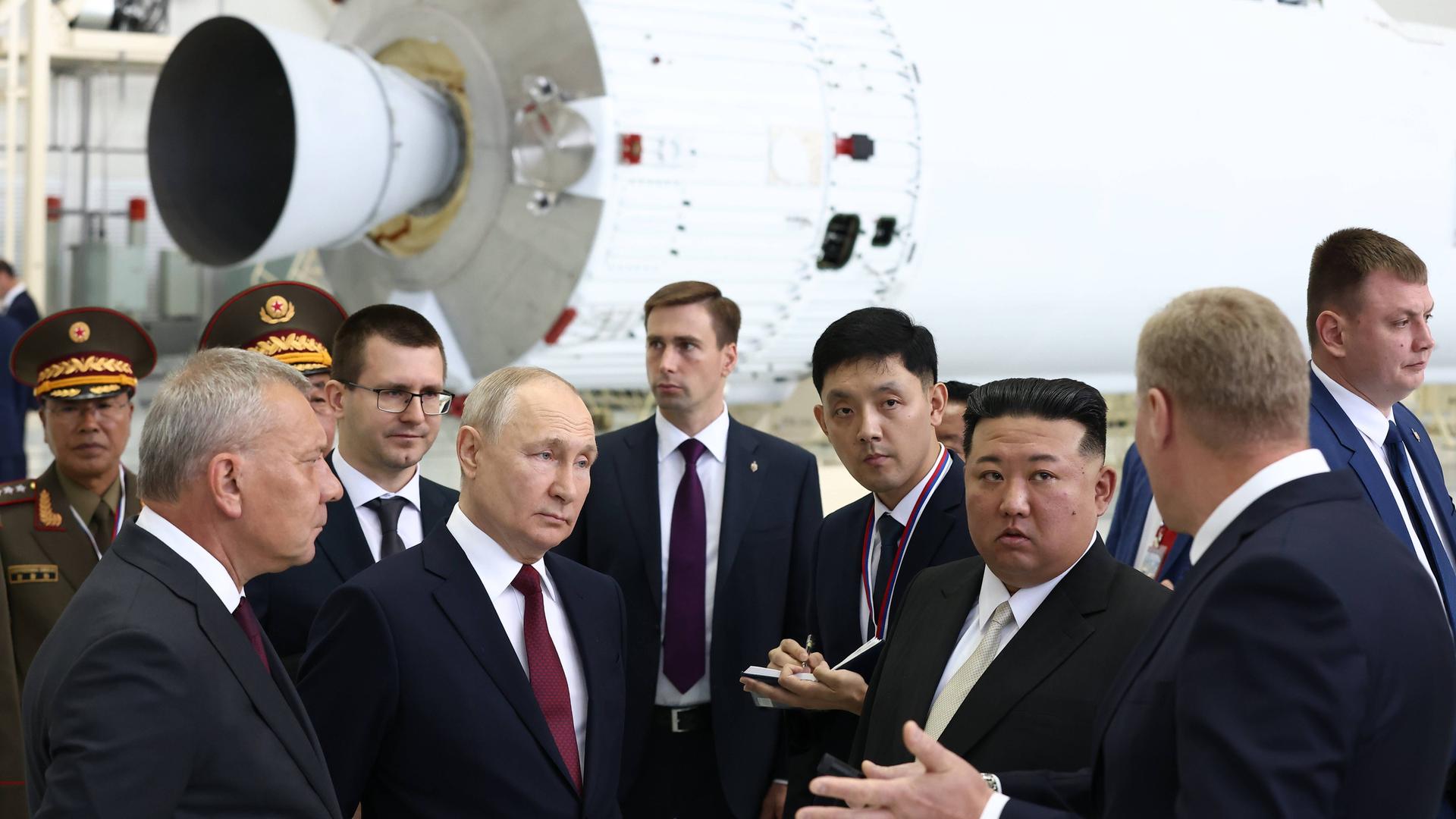 Russland: Präsident Wladimir Putin und Nordkoreas Machthaber Kim Jong Un treffen sich am Weltraumbahnhof Wostotschny. Mehrere Personen stehen um sie herum.