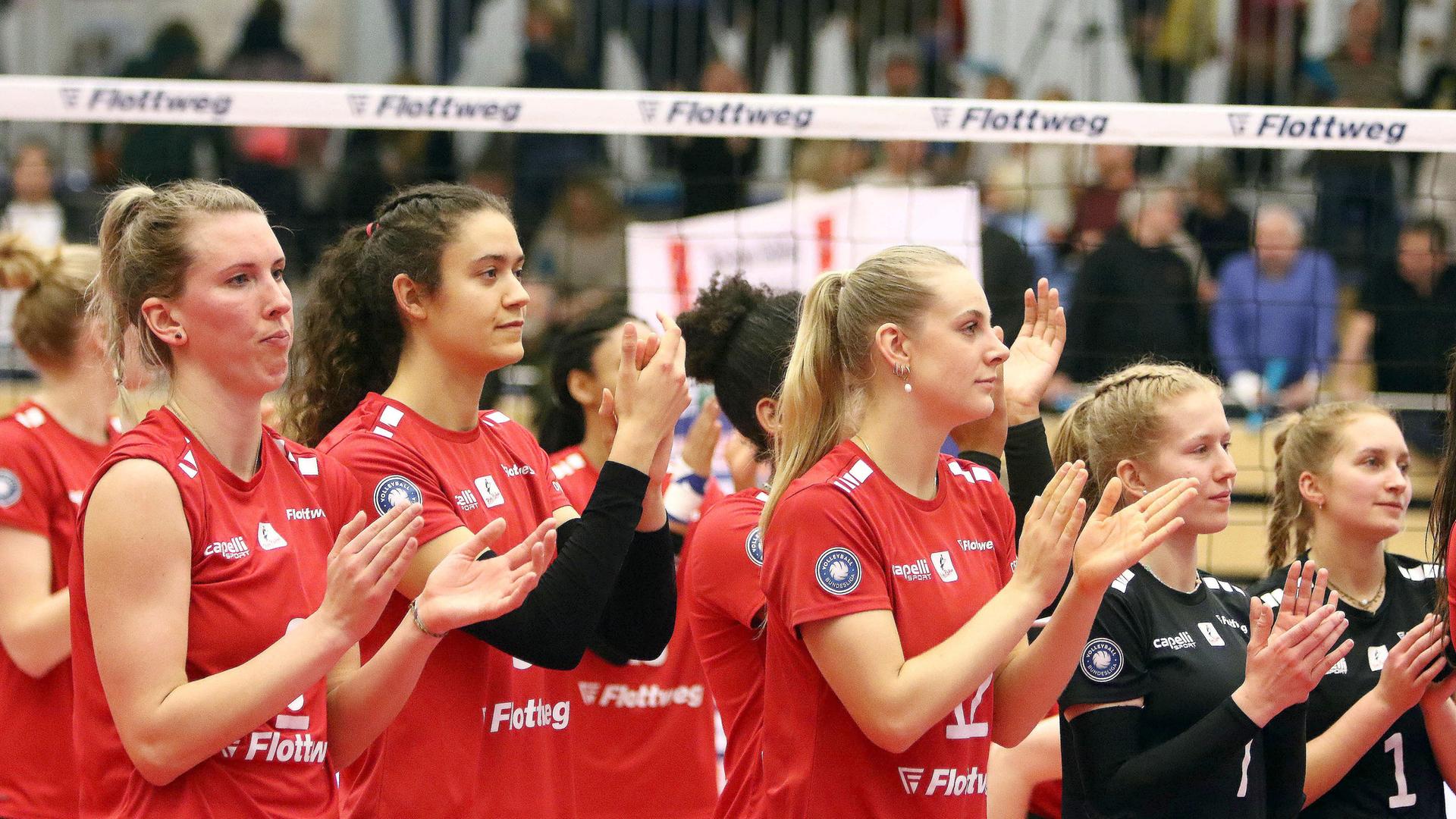 Vilsbiburger Spielerinnen nach der Niederlage stehen enttäuscht vor dem Volleyballnetz und bedanken sich bei den Fans