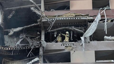 Feuerwehrleute arbeiten nach israelischen Angriffen am Ort einer Explosion in einer Wohnanlage im Norden von Teheran. 