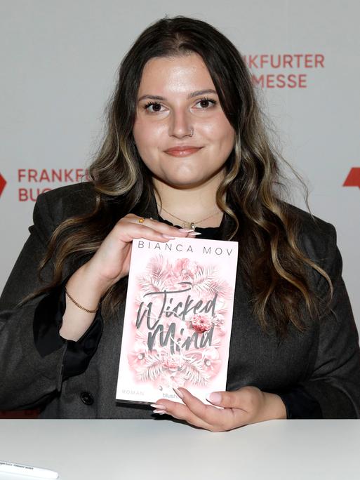 Bianca Mov hält ihr Buch "Wicked Mind" in die Kamera Bianca Mov hält ihr Buch "Wicked Mind" in die Kamera