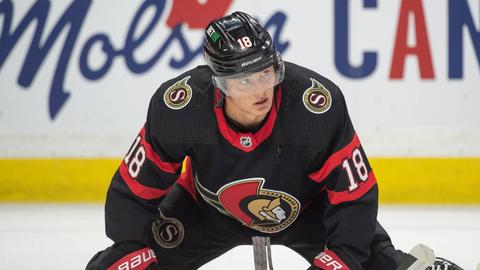 Eishockeyspieler Tim Stützle kniet auf dem Eis und blickt nach oben.