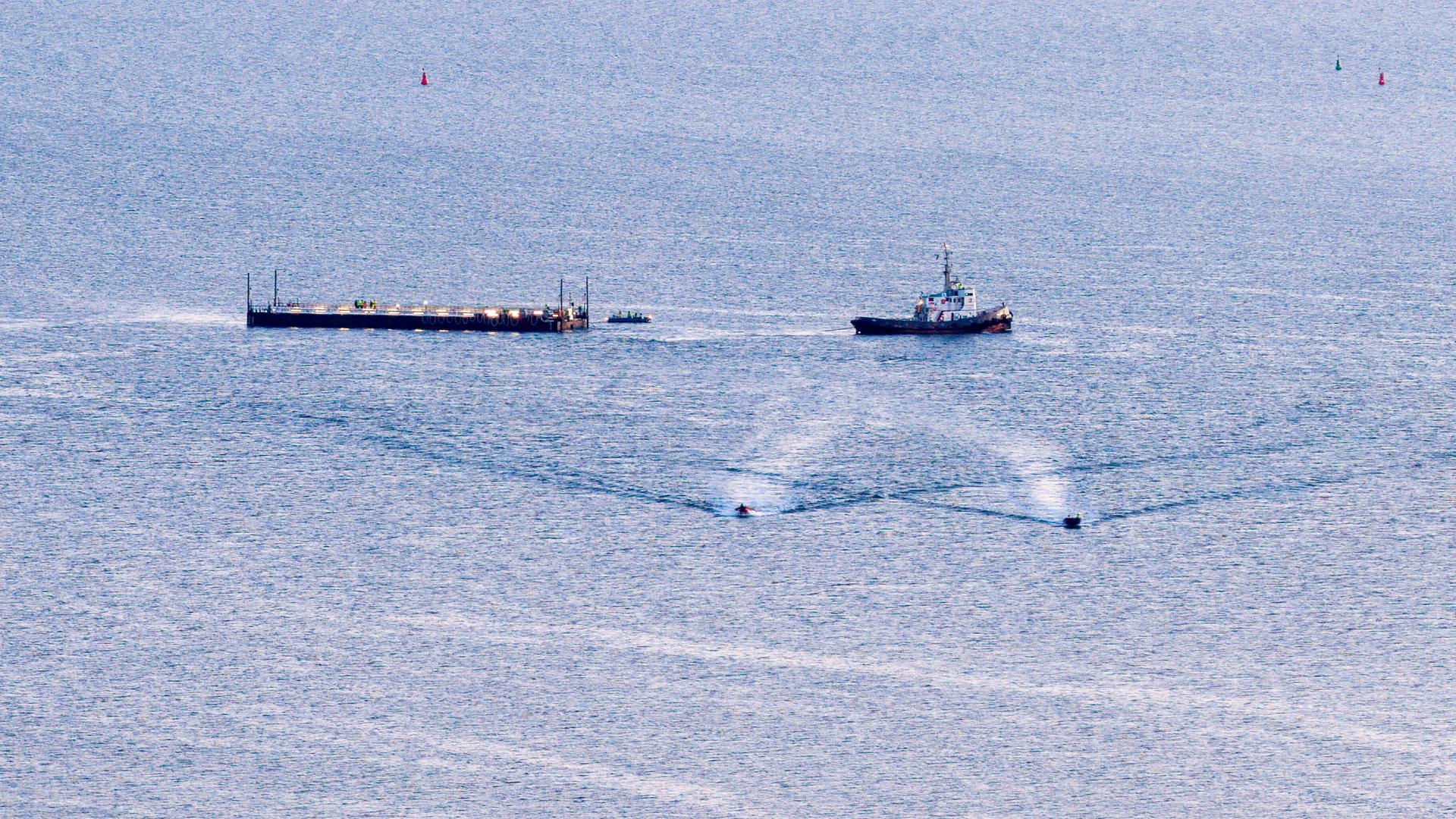 Das Schiff „Robin Hood“ zieht vor Wismar die Barge mit dem gestrandetem Wal in Richtung Ostsee (Luftaufnahme mit einer Drohne).