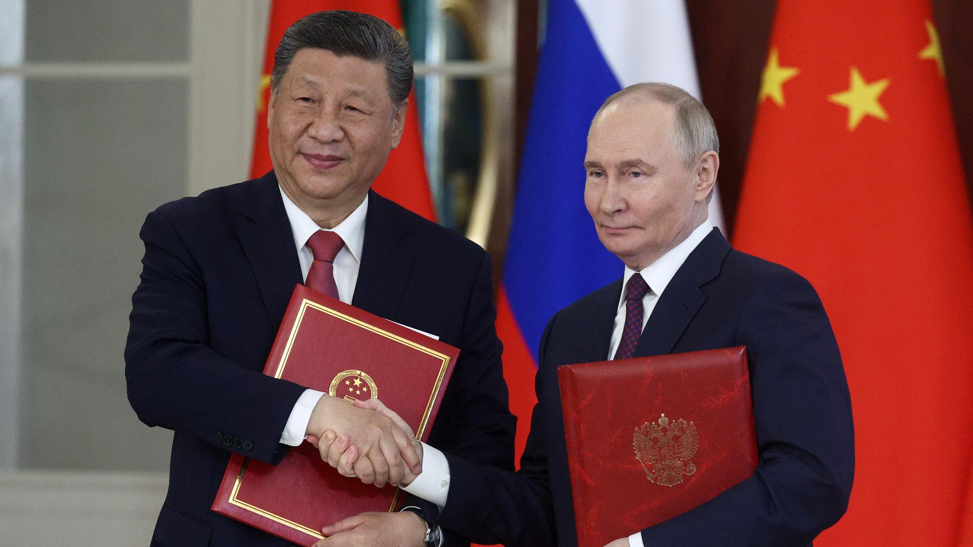 Xi Jinping und Wladimir Putin reichen sich die Hände