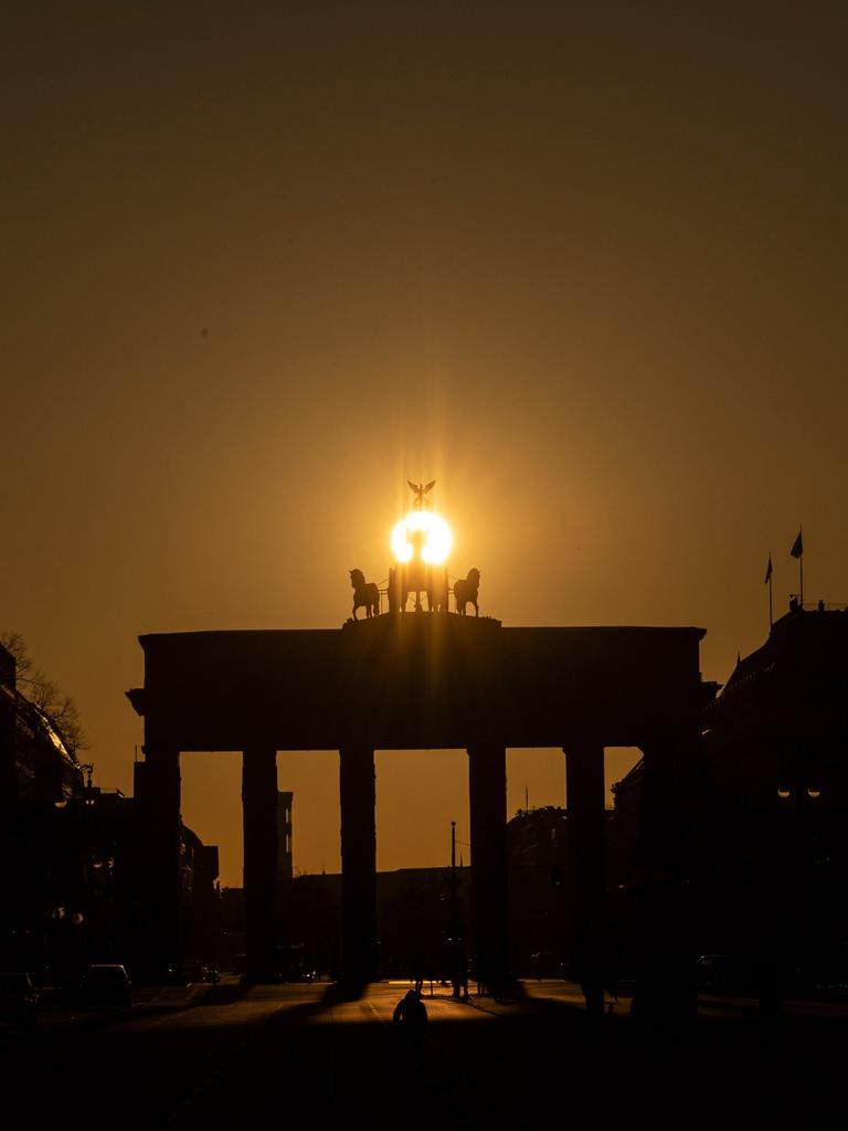 Die Sonne geht hinter dem Brandenburger Tor auf.