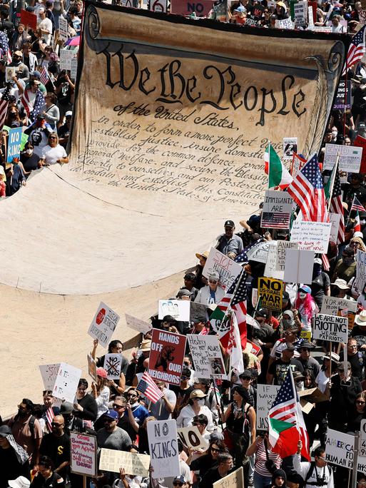Demonstranten tragen während einer Anti-Trump-Demonstration unter dem Motto „No Kings Day“ 2025 in Los Angeles ein übergroßes Transparent mit dem Wortlaut der Präambel der US-Verfassung.