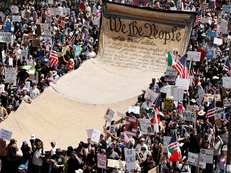 Demonstranten tragen während einer Anti-Trump-Demonstration unter dem Motto „No Kings Day“ 2025 in Los Angeles ein übergroßes Transparent mit dem Wortlaut der Präambel der US-Verfassung.