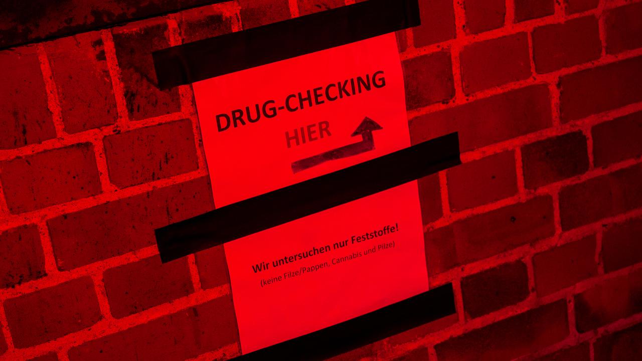 Schild mit der Aufschrift "Drug-Checking hier" vor einer Schweriner Disko