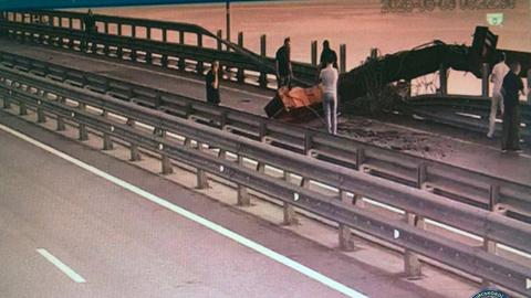 Ukrainische Sicherheitsleute schaut sich die Beschädigung an der Brücke zwischen der Krim und Russland an.