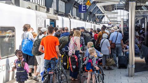 Viele Menschen versuchen mit Gepäck und Rädern in einen Zug zu kommen (Bahnsteig im Hauptbahnhof Karlsruhe, 12.6.2025)
