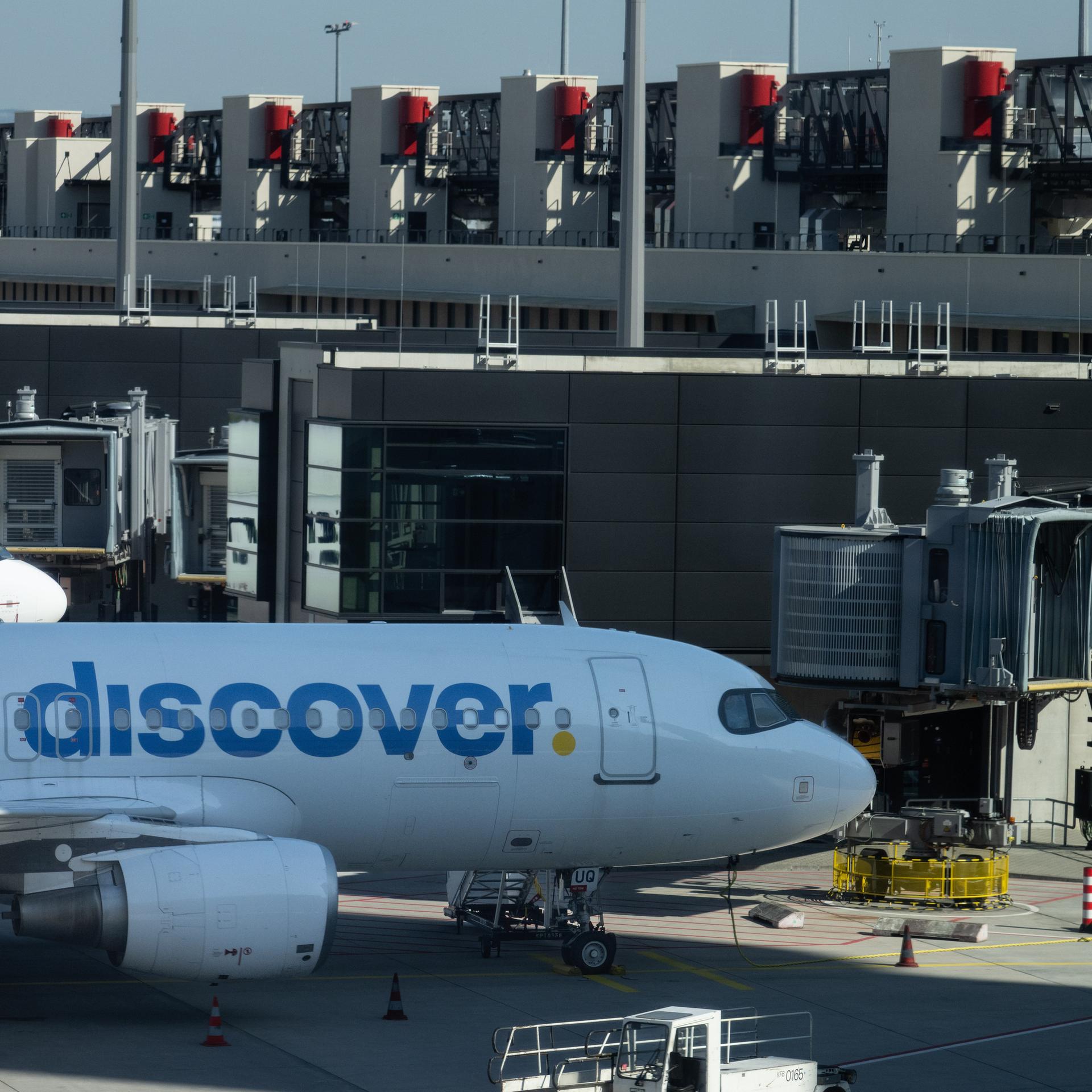 Flugzeuge verschiedener Airlines, darunter Discover, stehen an den Fingern des neuen Terminals.  