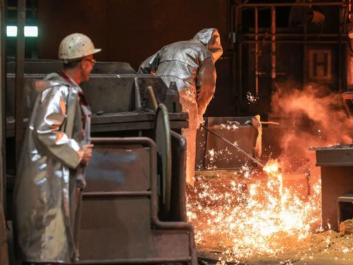 Stahlarbeiter ziehen im Stellwerk von Thyssenkrupp eine Probe. 