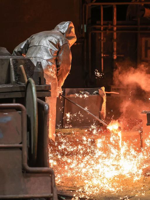 Stahlarbeiter ziehen im Stellwerk von Thyssenkrupp eine Probe. 