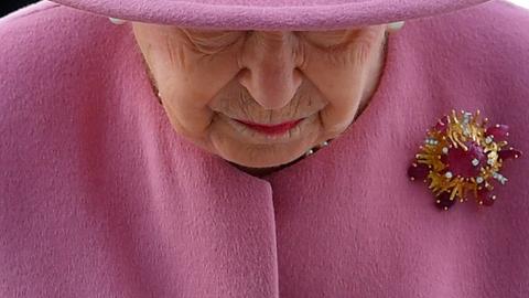Die britische Queen Elizabeth II. senkt ihren Kopf.