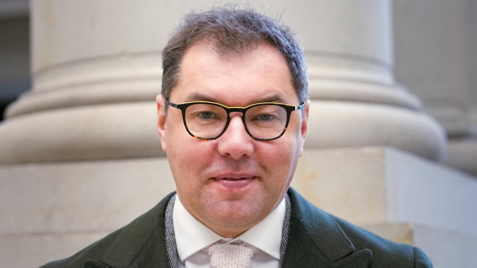 Porträt von Oleksii Makeiev, dem Botschafter der Ukraine in Berlin. Er trägt Anzug, einen Mantel und eine Brille und schaut geradeaus in die Kamera.