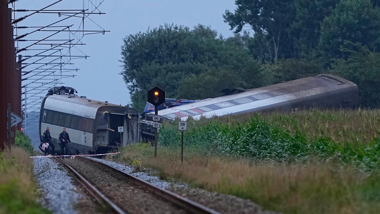 Zwei Zugwaggons liegen nach einem Unfall abseits der Strecke.