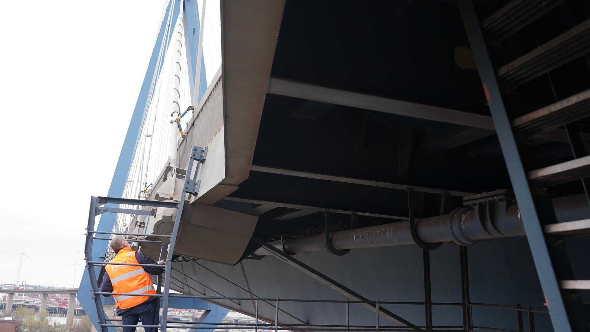 Ein Mitarbeiter der Hamburg Port Authority (HPA) steht auf einer Außenplattform des Stahlbrückenabschnitts unter der Fahrbahn der Köhlbrandbrücke im Hamburger Hafen. Ein Mitarbeiter der Hamburg Port Authority (HPA) steht auf einer Außenplattform des Stahlbrückenabschnitts unter der Fahrbahn der Köhlbrandbrücke im Hamburger Hafen.