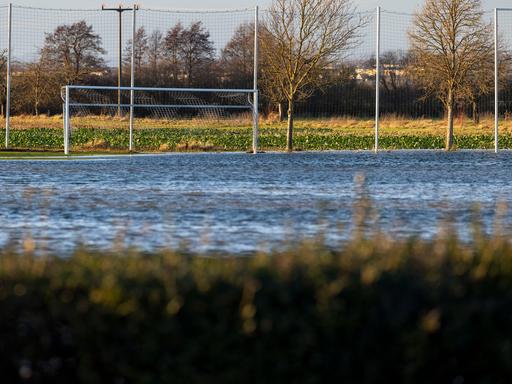 Ein Fußballplatz steht unter Wasser.