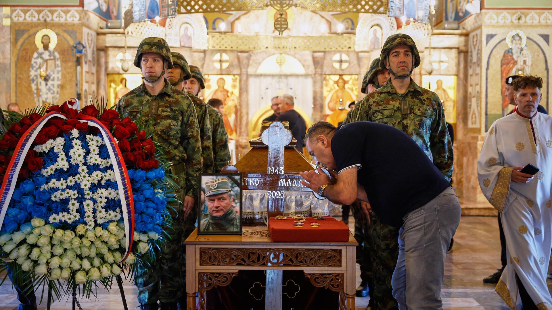Belgrad: Ein Mann berührt das Kreuz, während serbische Soldaten um den Sarg des ehemaligen bosnisch-serbischen Armeekommandanten Ratko Mladic stehen. Belgrad: Ein Mann berührt das Kreuz, während serbische Soldaten um den Sarg des ehemaligen bosnisch-serbischen Armeekommandanten Ratko Mladic stehen.