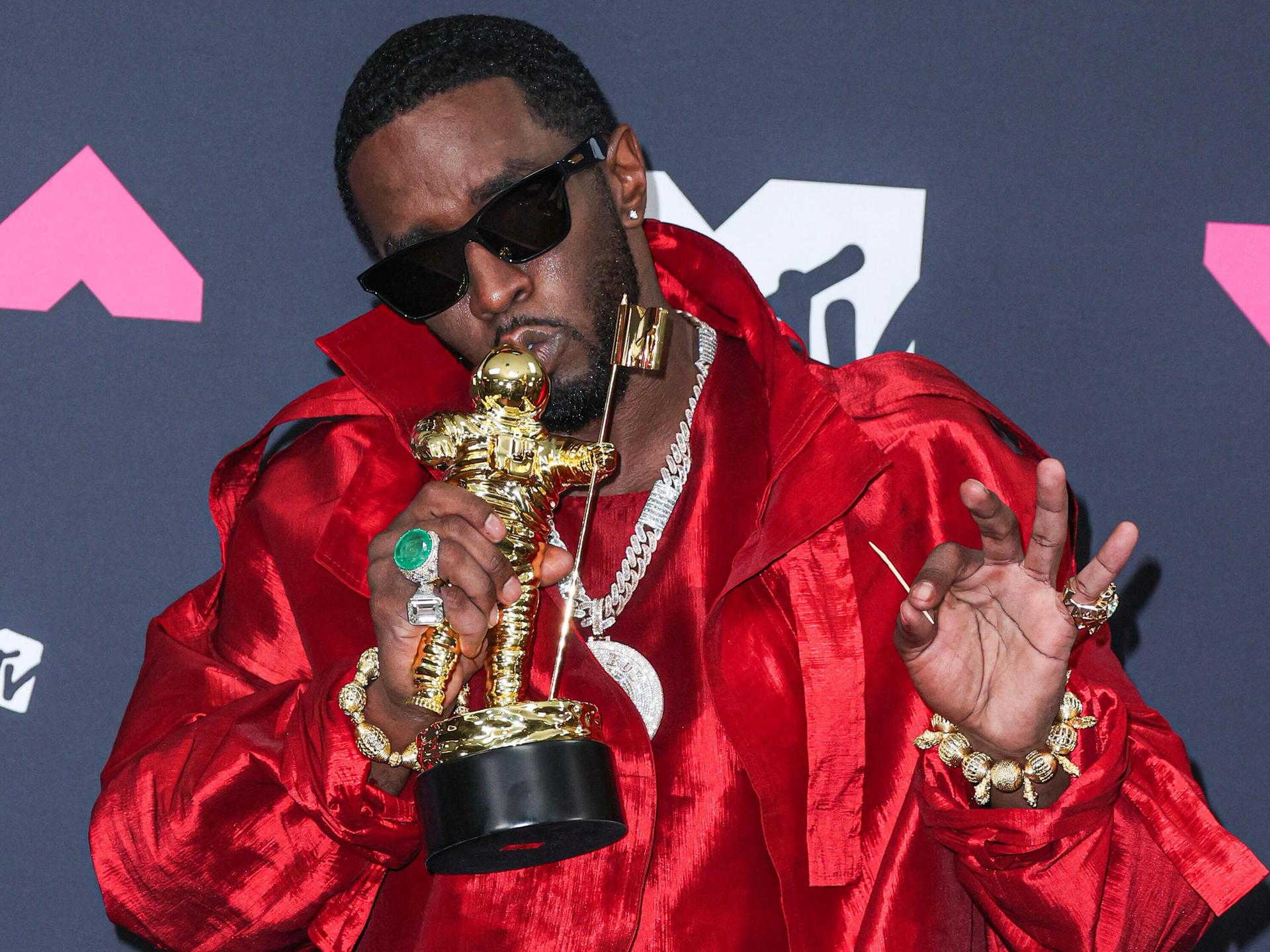 Der Rapper Sean Combs alias P. Diddy posiert mit einem Preis bei den MTV Music Awards vor der Kamera, er trägt eine Sonnenbrille. 