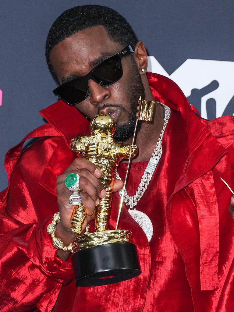 Der Rapper Sean Combs alias P. Diddy posiert mit einem Preis bei den MTV Music Awards vor der Kamera, er trägt eine Sonnenbrille. 