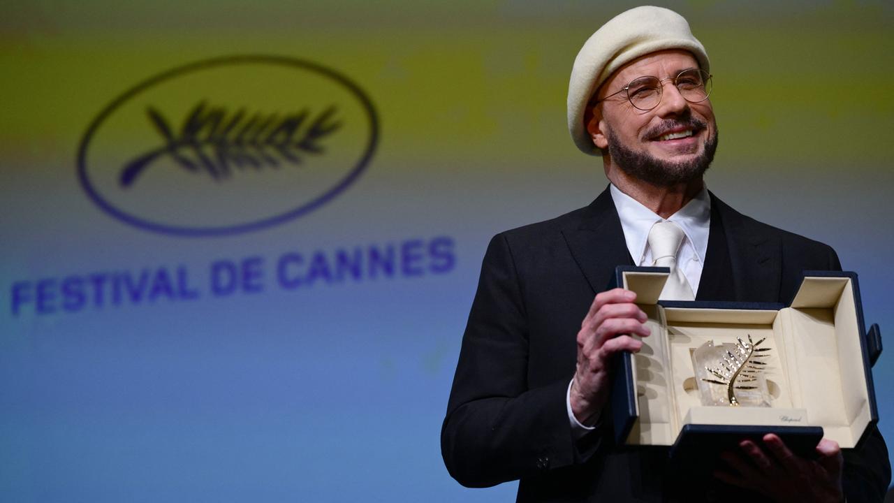 Das Foto zeigt den US-Schauspieler und Regisseur, John Travolta, mit der Ehrenpalme in Cannes.
      